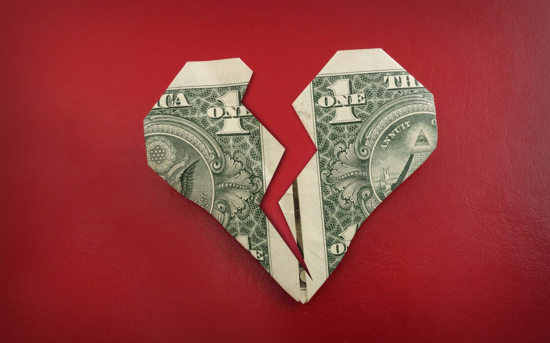 Broken heart made of dollar bills on red background